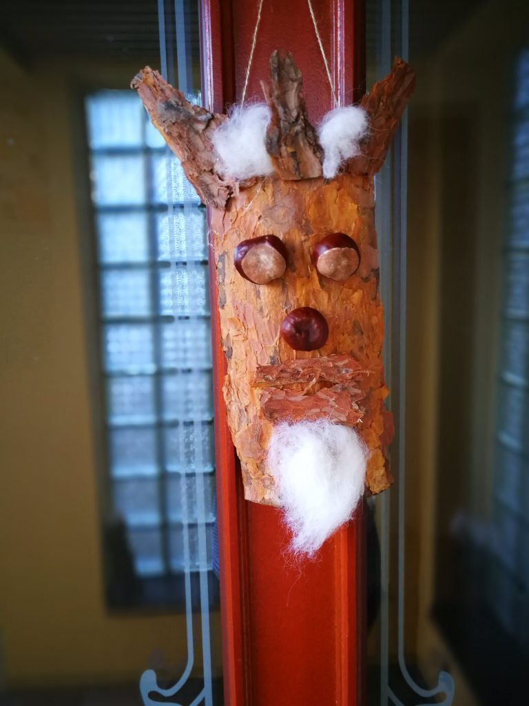 gebasteltes Gesicht aus Baumrinde aus Naturmaterial hängend als Türkranz